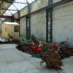 Erdfläche mit Kunststoffobjekten, Holz , Zweigen , Islandmoos, Kunstblumen , Gartenhütte